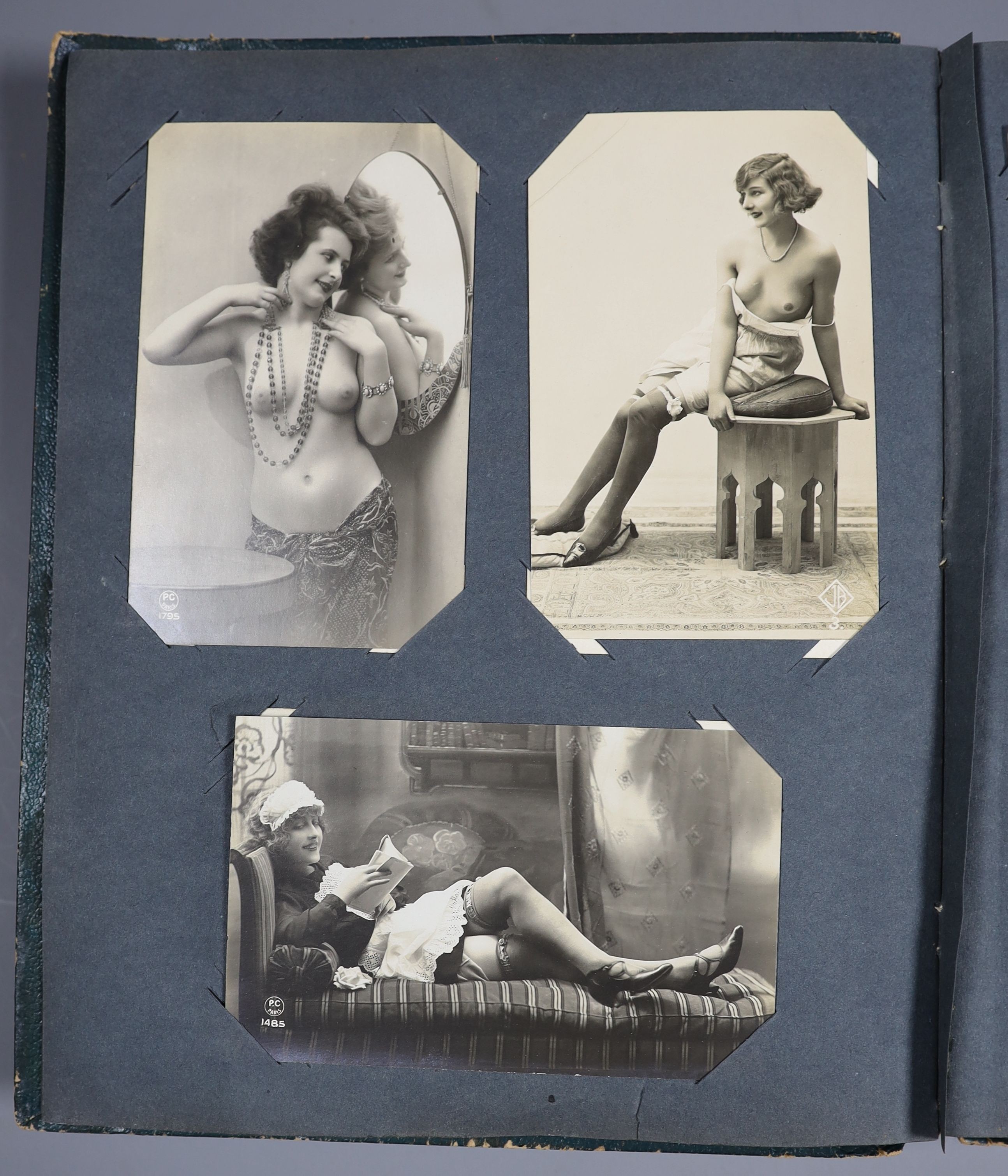 An Edwardian green postcard album, mounted with 68 risqué cards and a brown album mounted with Edwardian, George V and later, mainly topographical cards (2)